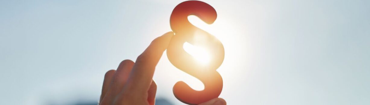 Fotoausschnitt einer Hand, die auf einen Rechtsparagrafen zeigt