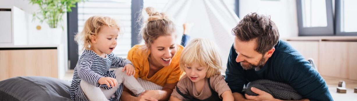 Vierköpfige Familie blickt gemeinsam auf ein Fotoalbum