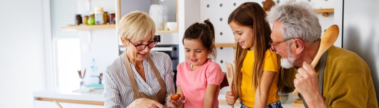 Vierköpfige Familie mit Großeltern bereitet gemeinsam eine Mahlzeit vor