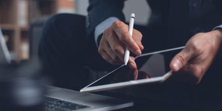 Fotoausschnitt einer Person, die mit einem Tablet-Stift auf das Display eines Tablets tippt